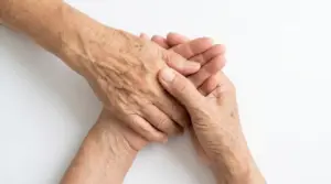 Primo piano di mani anziane con pelle sottile e vene visibili, possibile segnale legato all’osteoporosi