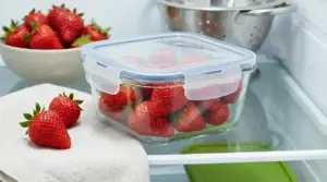 Fragole fresche conservate in un contenitore ermetico di vetro nel frigorifero