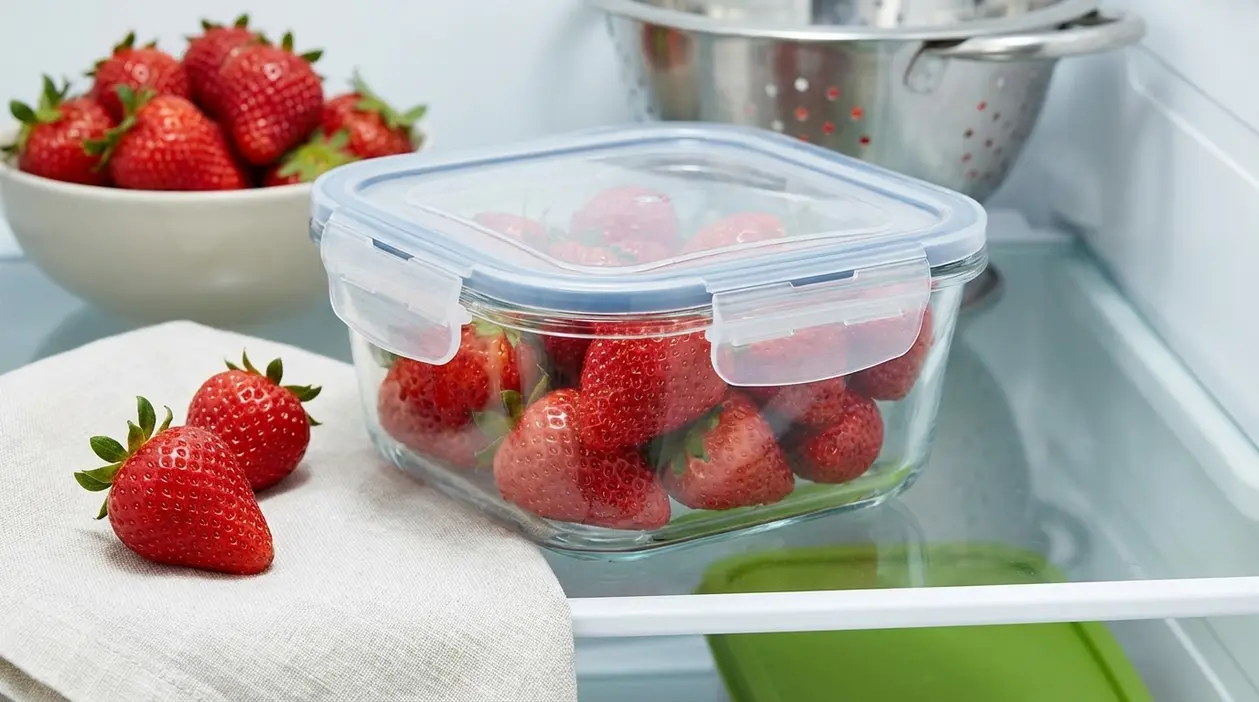 Fragole fresche conservate in un contenitore ermetico di vetro nel frigorifero