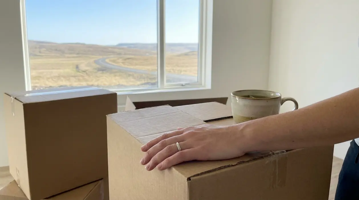 Una persona con la mano su uno scatolone in una stanza vuota, simbolo di lasciare una relazione tossica